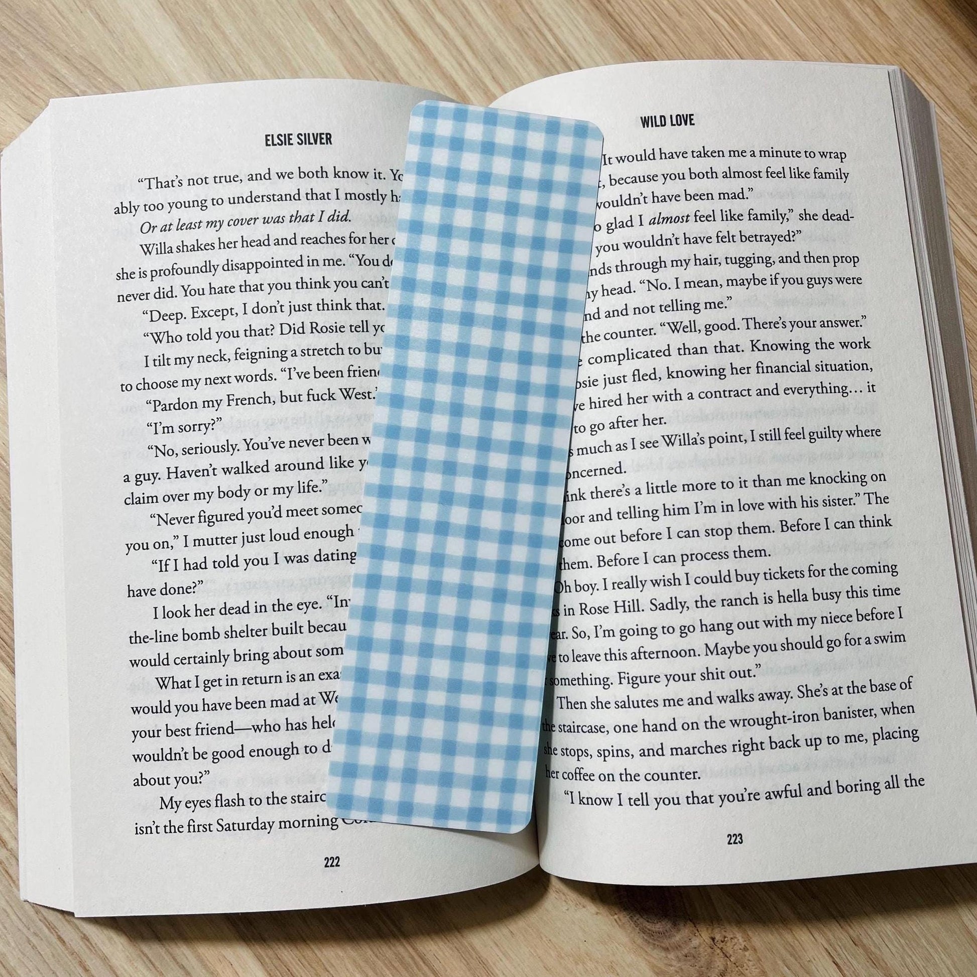 Open book with a blue and white checkered bookmark on a wooden surface