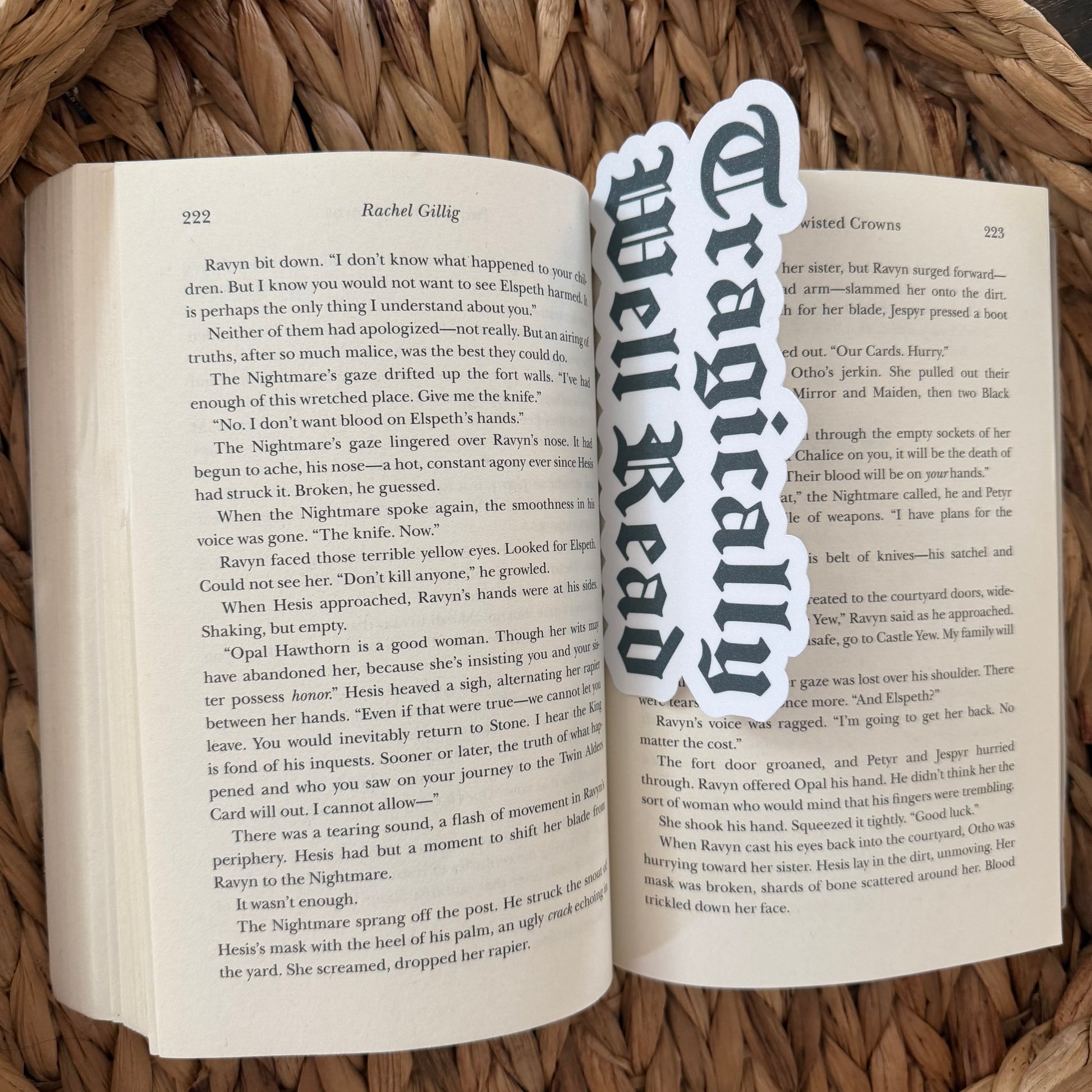 Open book with a bookmark labeled 'Tragically Well Read' on a woven surface