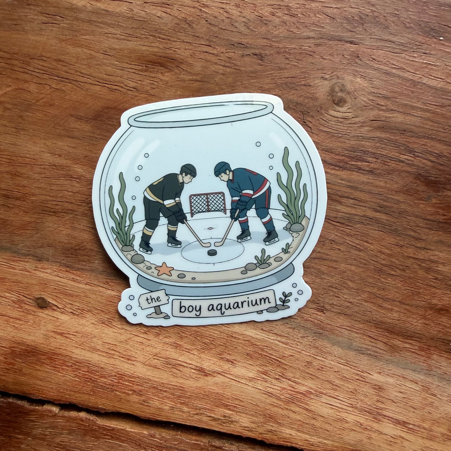 Sticker of two hockey players in an aquarium on a wooden surface