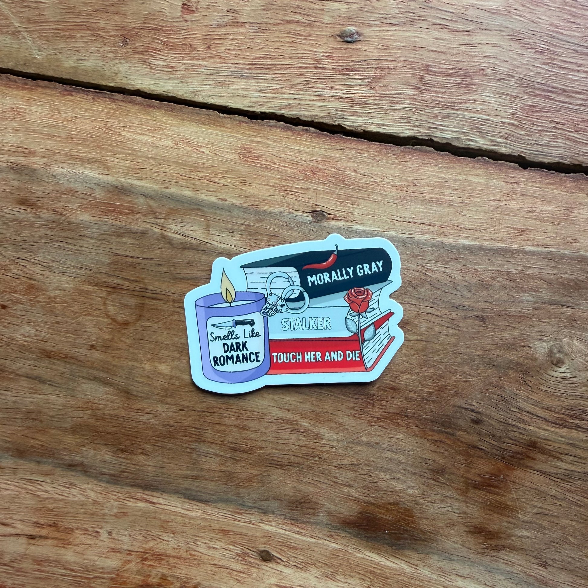 Sticker with book and candle design on a wooden surface