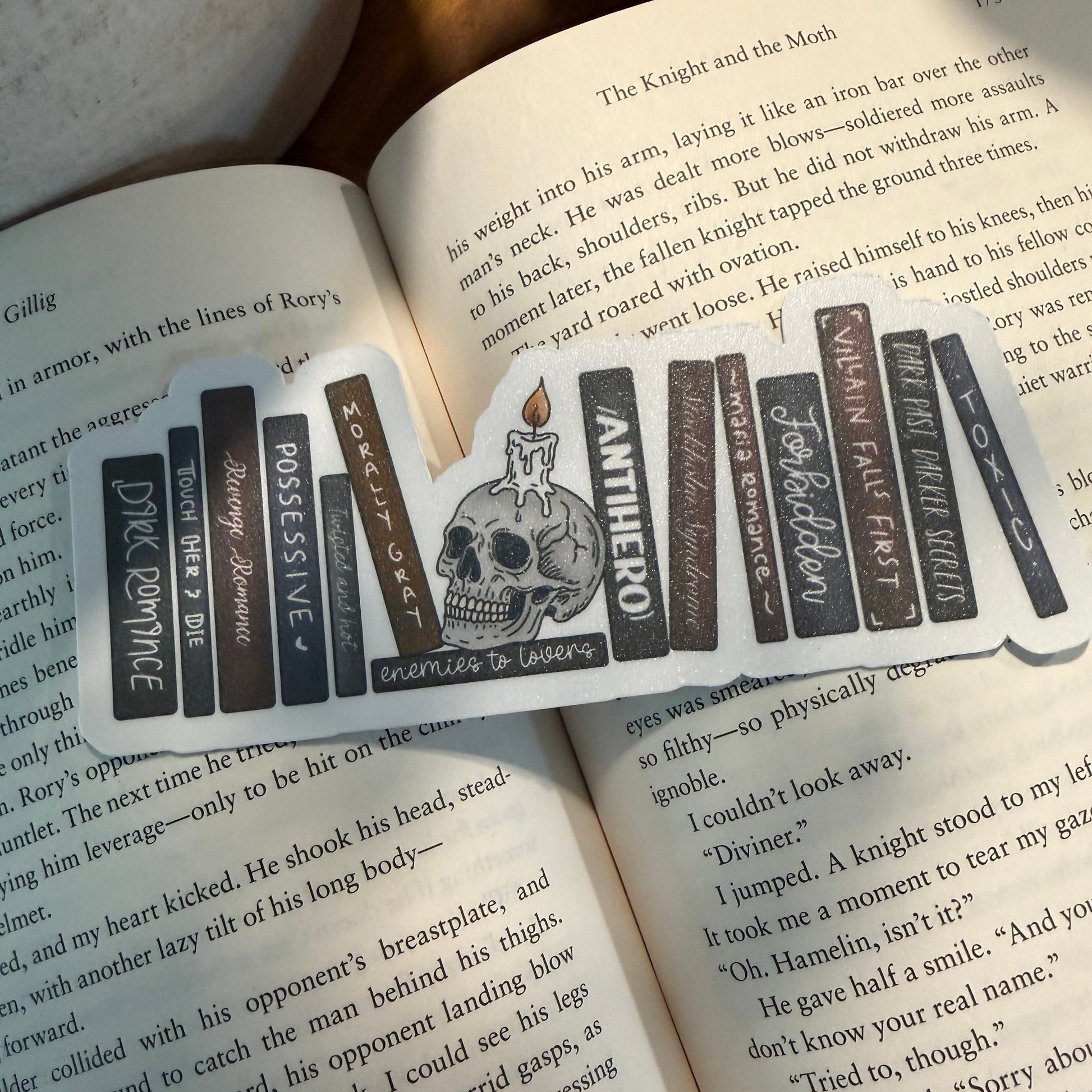 Book with a bookmark featuring text and a skull design on an open book.