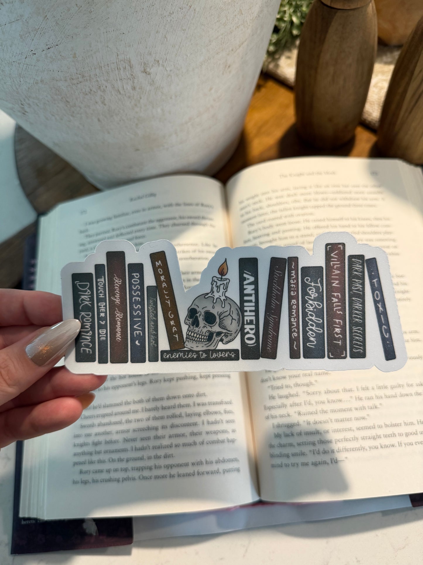 Hand holding a bookmark with text over an open book