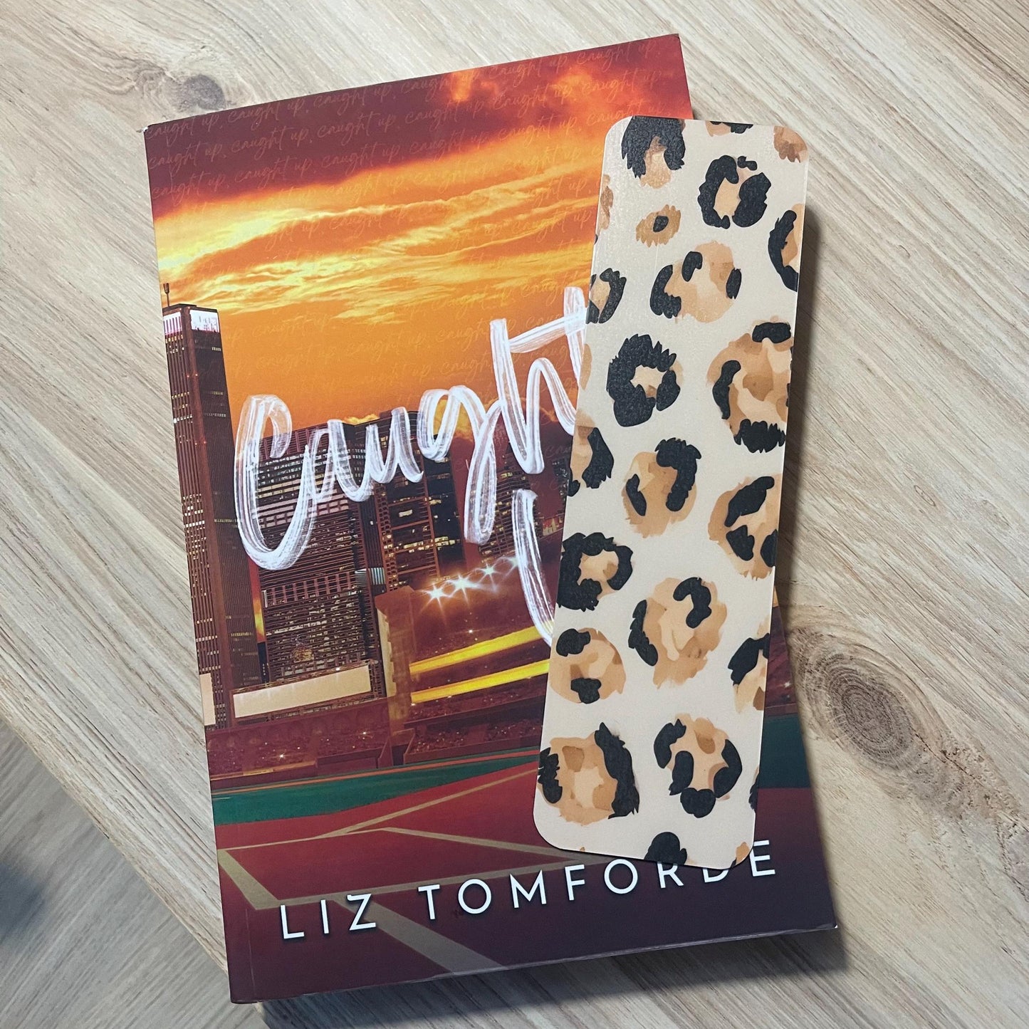 leopard print bookmark on top pf a book on a wooden surface