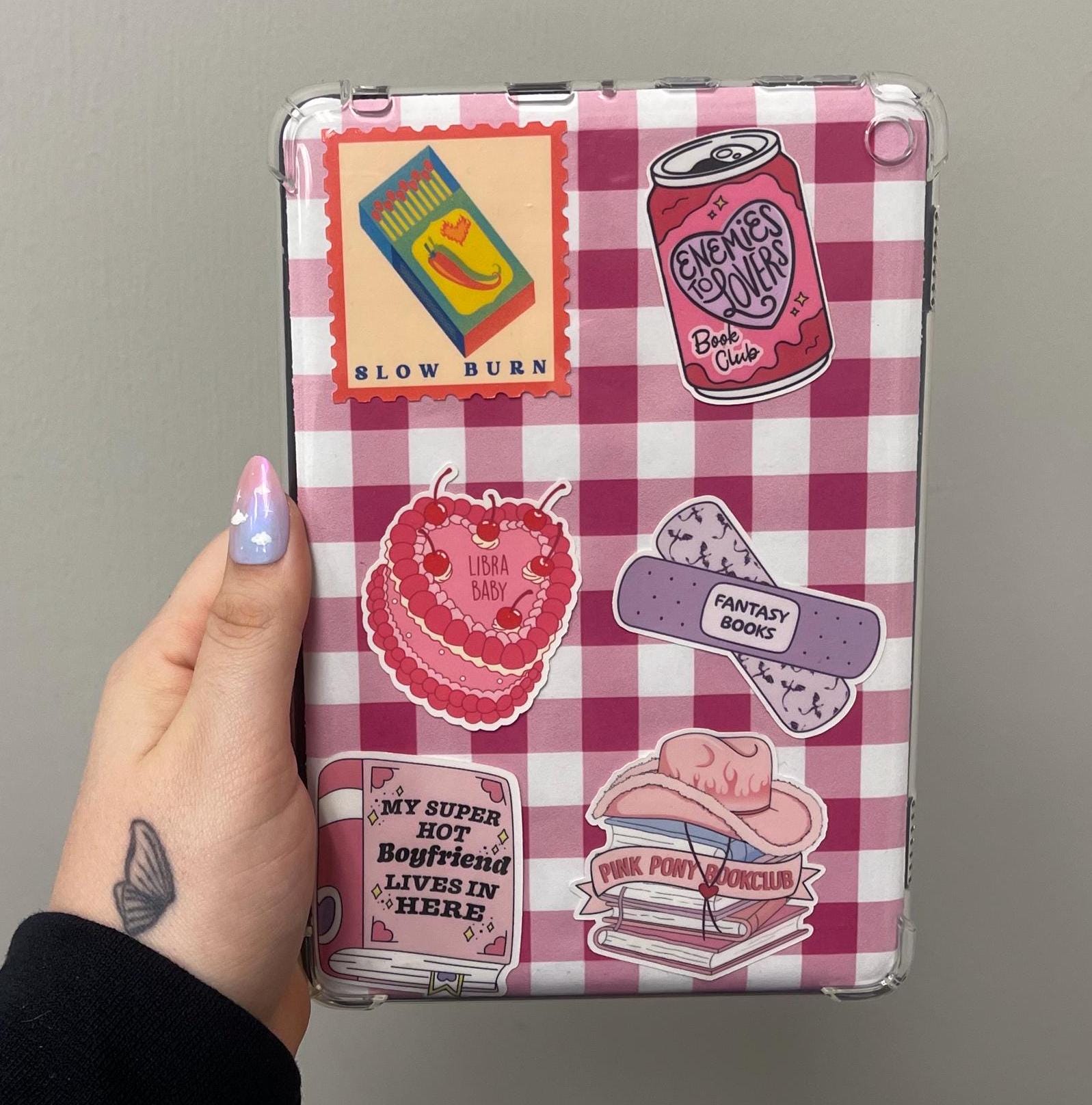 kindle case with pink and white checkered pattern and various stickers on a gray background