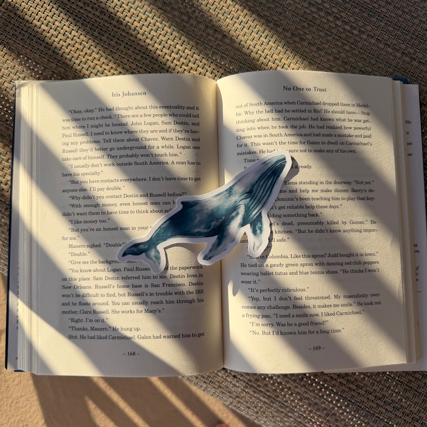 Open book with a whale-shaped bookmark on a textured surface